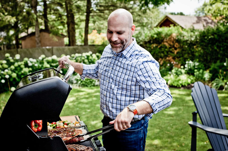 Man grilling outdoors in a backyard setting