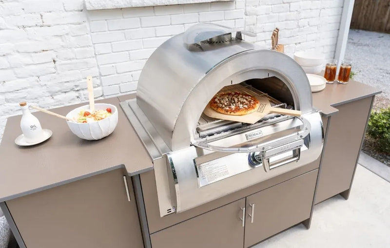 Outdoor pizza oven with a pizza inside on a countertop.