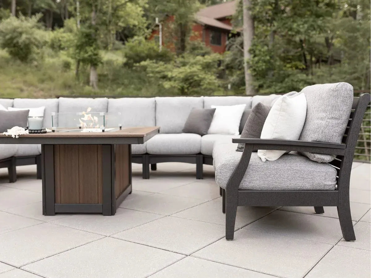 Outdoor patio furniture set with a sectional sofa and table on a tiled patio.