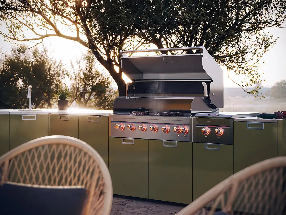 Crown Verity outdoor kitchen with a built-in stainless grill, side burner and sink set in olive green cabinetry.