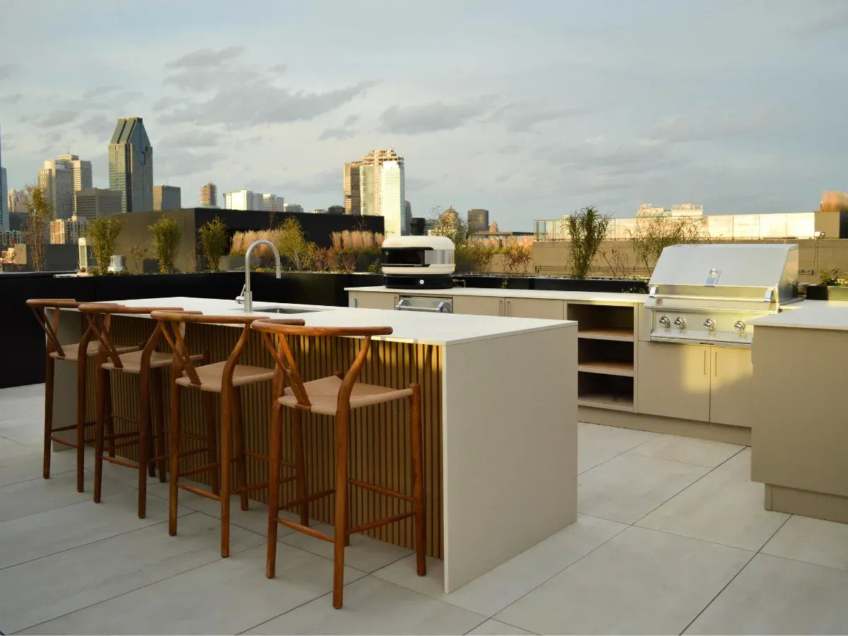 Outdoor kitchen area with bar stools and city skyline in the background